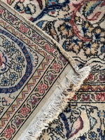 Underside view of vintage Persian rug with calm ivory ground and nature-inspired design.