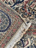 Underside view of vintage Persian rug with calm ivory ground and nature-inspired design.