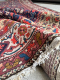Antique Persian rug displaying faint Dijon-tan and soft pink highlights.
