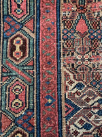 Persian runner showcasing cool blues, greens, and warm reds.