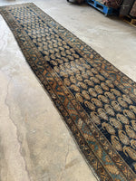 Vintage Persian runner with rows of paisley motifs on a navy-space blue field.