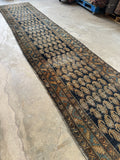Vintage Persian runner with rows of paisley motifs on a navy-space blue field.
