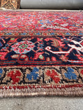 An authentic antique Persian Heriz rug made with handwoven wool.