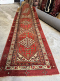Antique Persian Serab runner with three bold geometric medallions in brick red and ivory.