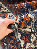 Antique Persian rug with floppy wool handle and authentic age throughout.