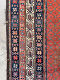 Hand-knotted Persian wool rug showing multi-banded borders filled with paisley and floral motifs.