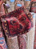 Antique Persian Bibikabad rug mat in red and turmeric yellow with central floral design.