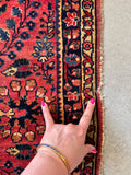 Vintage Sarouk rug close-up showing the small repaired area along one side.