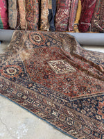 Vintage Shiraz Persian rug showing worn low wool pile and floppy handle.