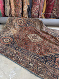 Vintage Shiraz Persian rug showing worn low wool pile and floppy handle.