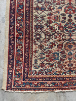Corner view of small antique Persian rug woven in vegetable dyed colors.