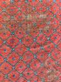 Persian terracotta area rug with subtle teal geometric grid pattern framing a distressed open field.