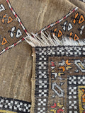 Underside view of antique 4x10 tribal runner with earthy camel tones, abrash, and geometric floral design.
