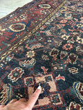 Vintage Persian village rug with durable wool construction for high traffic areas and showing a repair.
