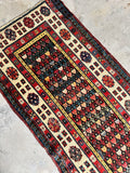 Battered and bruised antique tribal runner with visible repairs, patches and worn areas.