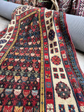Floppy worn Caucasian runner showing its supple handmade weave and aged wool pile.