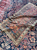 Antique Persian farmhouse rug with low pile, coral field and authentic century-old patina.