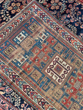 Hand-knotted Caucasian Kazak rug with traditional ram's horn symbols for strength and protection.