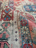 Worn distressed antique rug showing authentic edge wear, low pile texture, and historic mountain weaving.