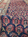 Hand-knotted tribal Persian runner with repeating boteh patterns.
