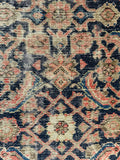 Close up view of shabby chic Persian runner with muted coral, tan and indigo tones.