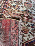Underside view of neutral and blush antique Gharajeh rug.