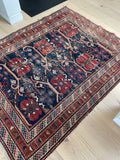 worn persian rug on wood floor displayed